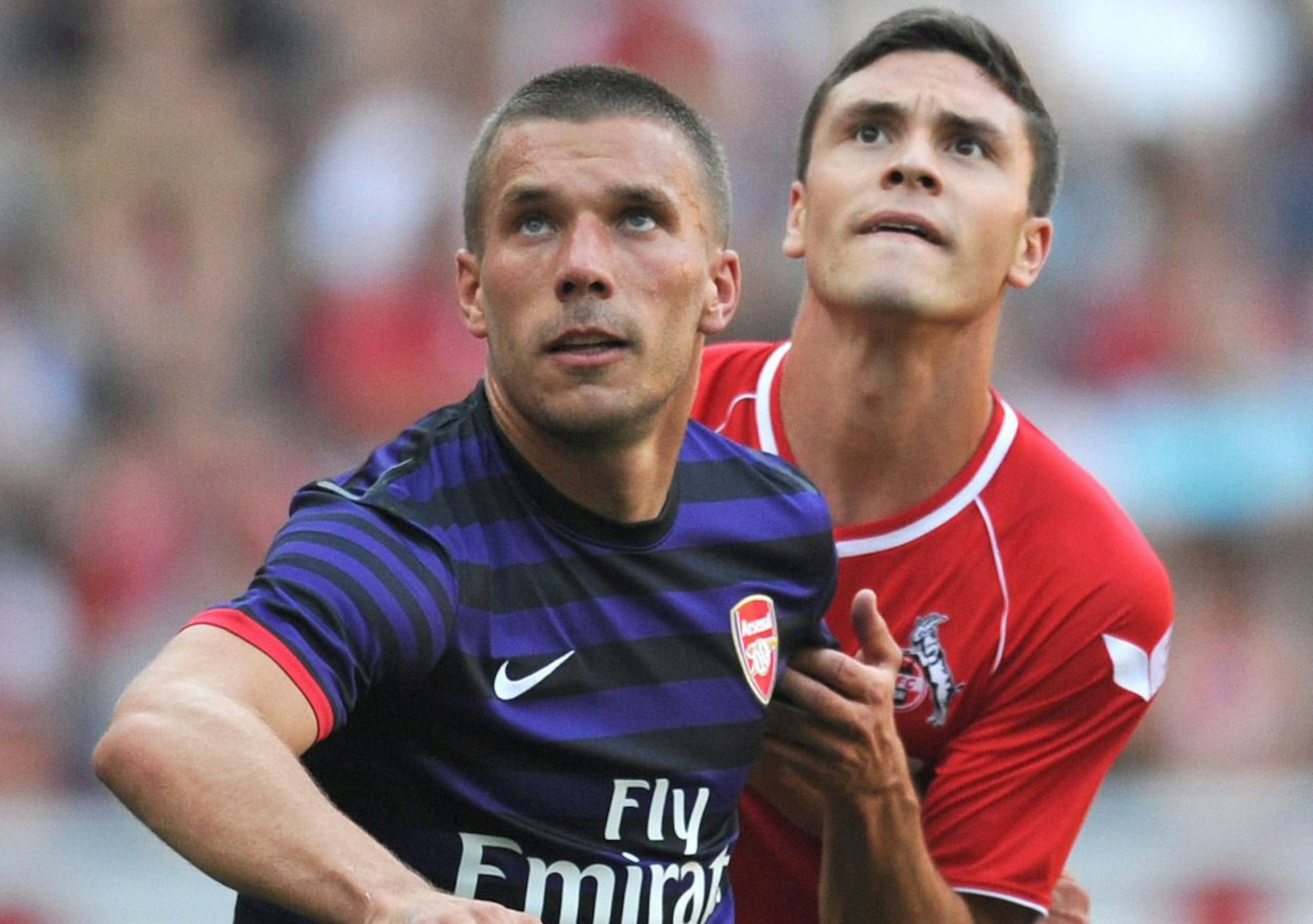 Arsenals Lukas Podolski (l.) und FC-Profi Jonas duellieren sich im Testspiel am 12. August 2012 in Köln.