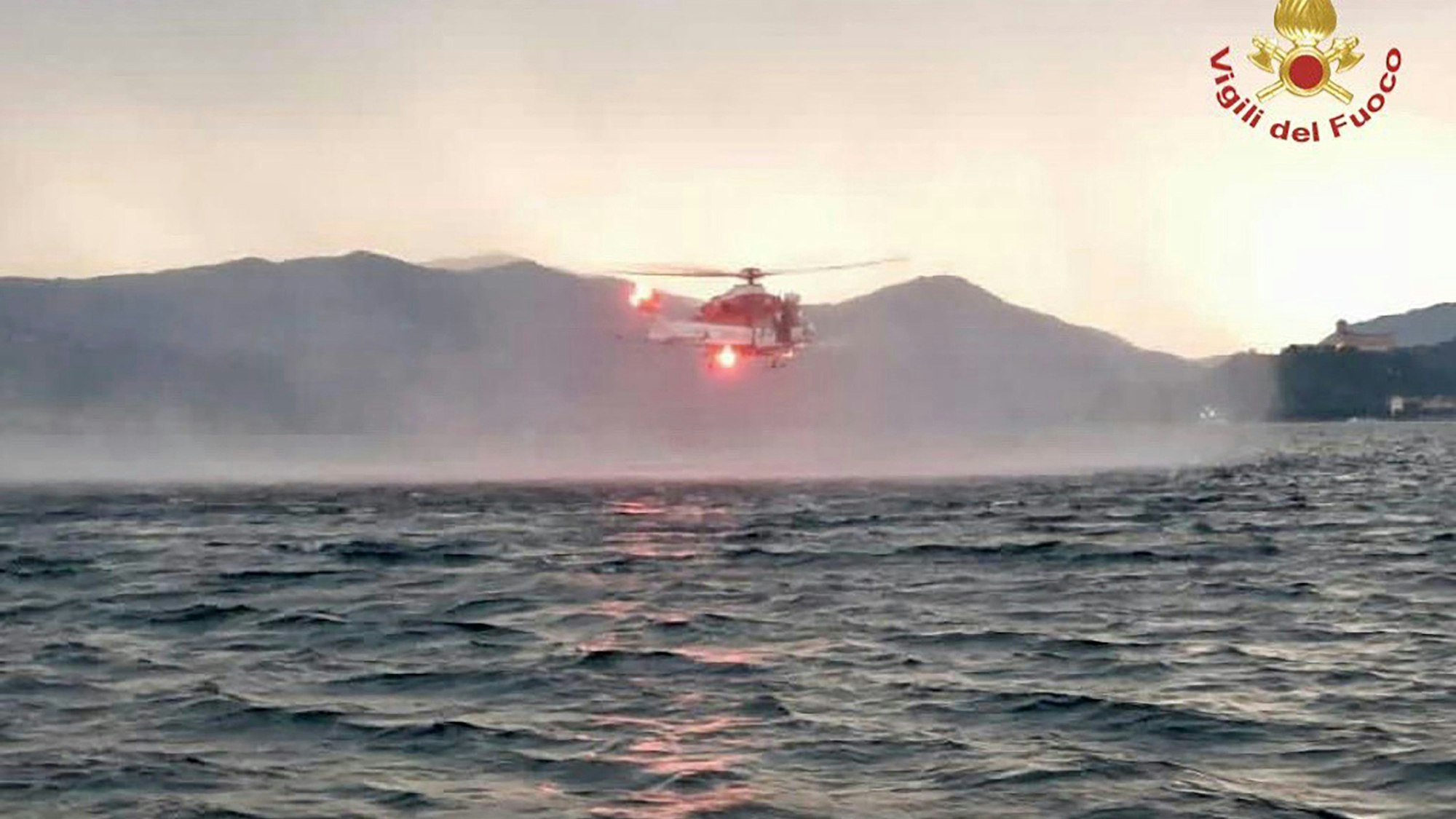 Dieses von der italienischen Feuerwehr veröffentlichten Bild zeigt einen Hubschrauber bei der Suche nach Vermissten, nachdem das Touristen-Boot in einem Sturm auf dem italienischen Lago Maggiore gekentert war.
