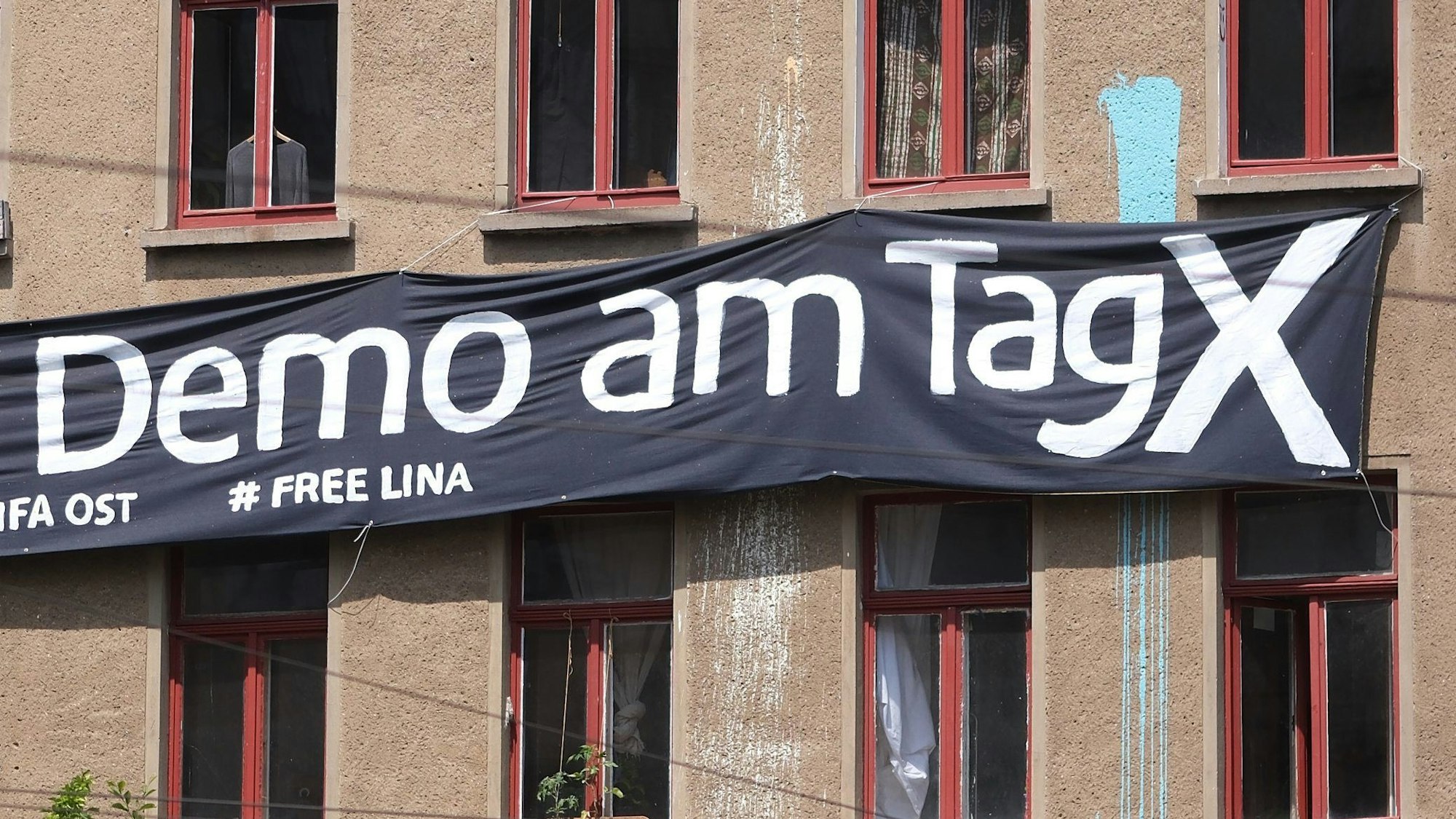 Ein Transparent mit der Aufschrift „Demo am Tag X“ und „# Free Lina“ hängt an der Fassade eines Hauses im Osten der Stadt.