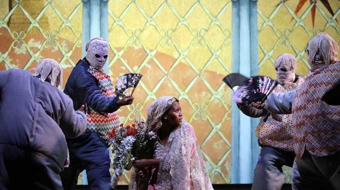 Das Szenenbild aus der südafrikanischen Musiktheater-Produktion „Samson“ zeigt die Braut des Helden von maskierten Männern bedrängt.&nbsp;
