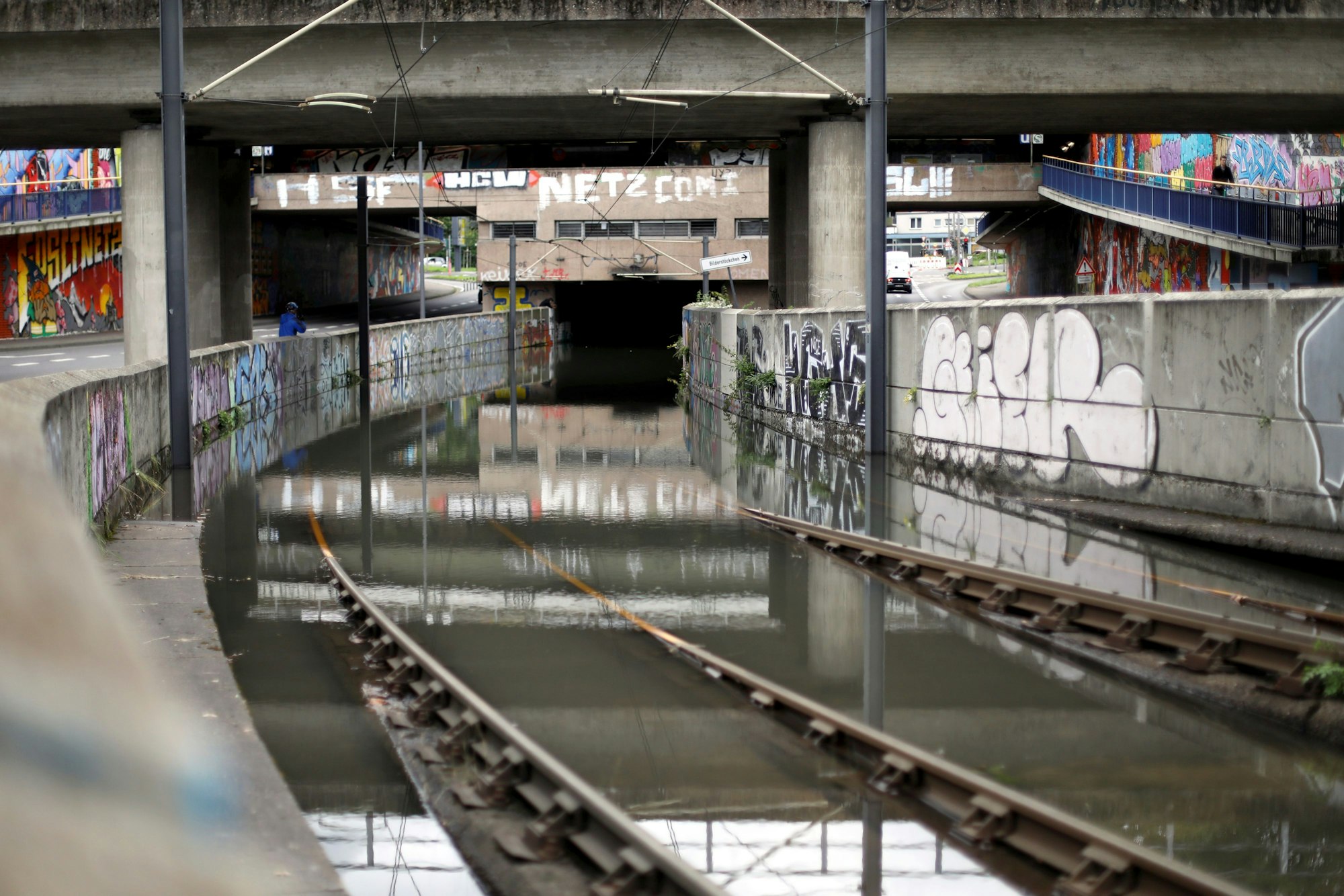Gleise, die in eine Unterführung münden, stehen im Wasser.