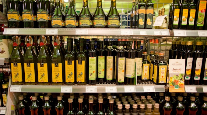 Regal mit Olivenölflaschen in einem Biosupermarkt.