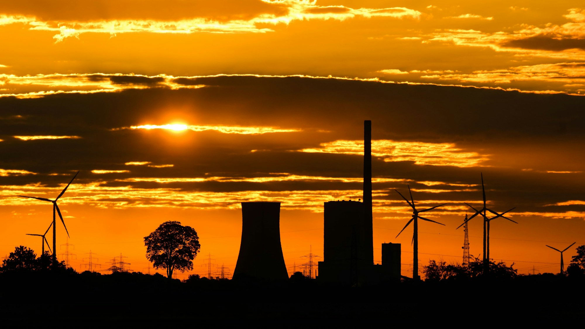 Die Sonne geht zwischen Wolken hinter dem Kraftwerk Mehrum im Landkreis Peine auf. Das Kohlekraftwerk ist seit dem 1. August als erster ·Marktrückkehrer· wieder am Netz. Eine Verordnung erlaubt, dass Steinkohlekraftwerke aus der sogenannten Netzreserve wieder in Betrieb gehen können, um Erdgas einzusparen.