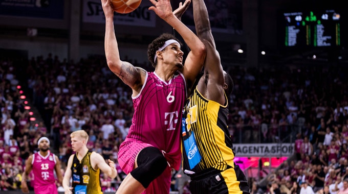 Michael Kessens (l.) von den Telekom Baskets Bonn zieht gegen Eddy Edigin zum Korb.