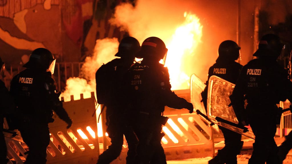 Polizisten gehen an einer brennenden Barrikade vorbei, hier im Juni 2023 in Leipzig.&nbsp;