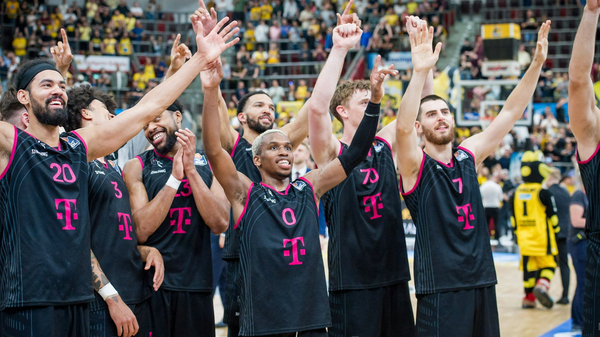 Jubel bei den Baskets: Mit dem Sieg in Ludwigsburg haben sie sich für die Play-off-Finals qualifiziert. Spieler stehen mit augebreiteten Armen und glücklichen Gesichtern nebeneinander.
