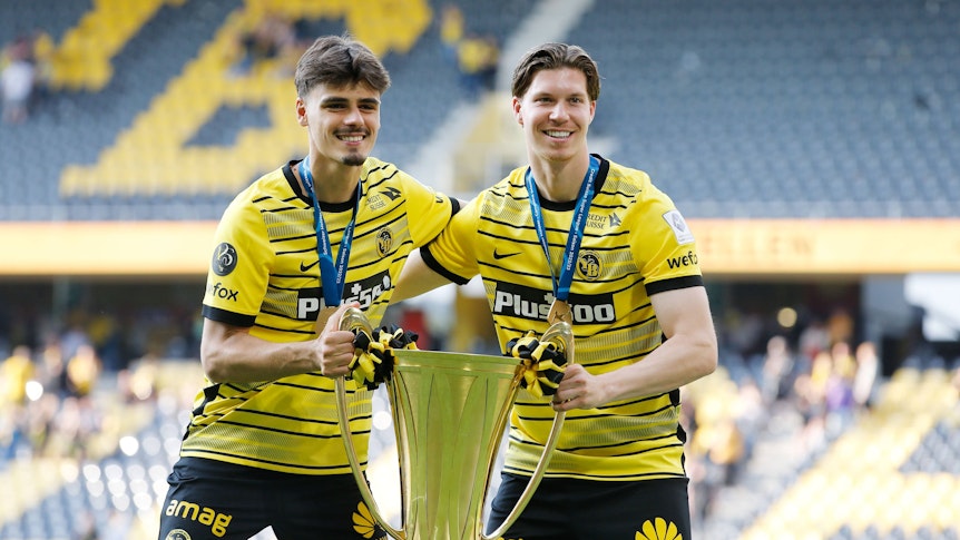 Donat Rrudhani (l.) und Cedric Itten am 29. Mai 2023 feiern die Meisterschaft der Schweizer Super League mit Young Boys Bern. In den Händen halten sie den goldenen Pokal.