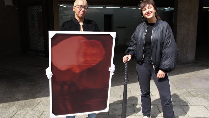 Die Künstlerinnen Nora Hase (l.) und Marleen Rothaus zeigen ihre Werke, ein Gemälde und ein Keramik-Baseballschläger.