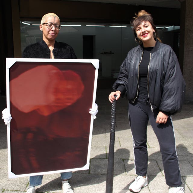 Die Künstlerinnen Nora Hase (l.) und Marleen Rothaus zeigen ihre Werke, ein Gemälde und ein Keramik-Baseballschläger.