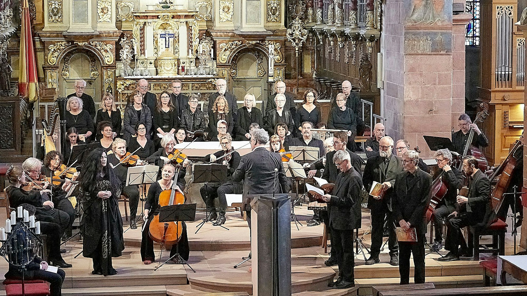Ein Chor und ein Orchester musizieren im Altarraum der Steinfelder Basilika.