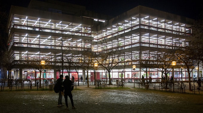 Außenansicht der beleuchteten Kölner Zentralbibliothek am Neumarkt in der Nacht.