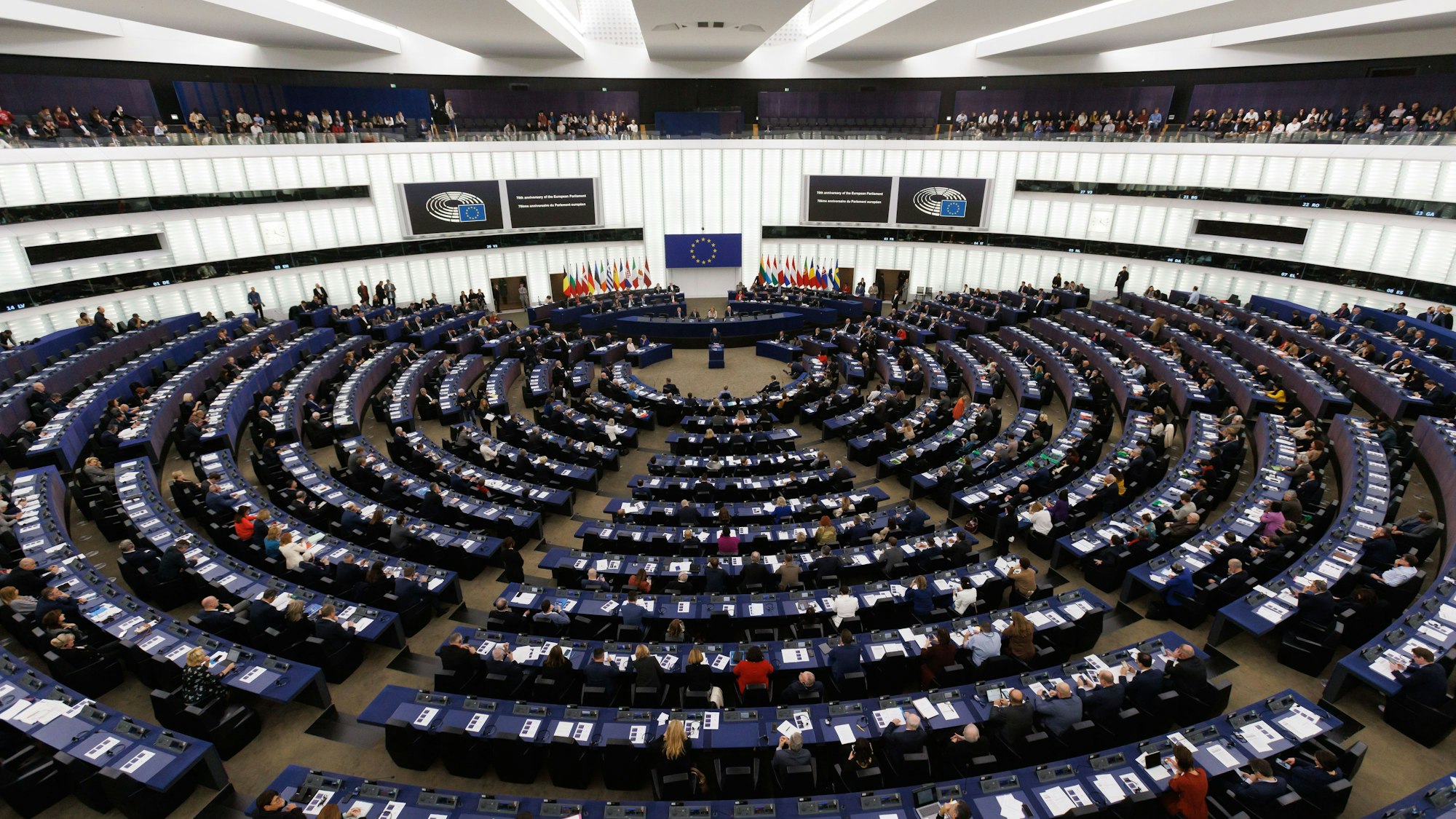 Abgeordnete und Gäste sitzen im Gebäude des Europäischen Parlaments.