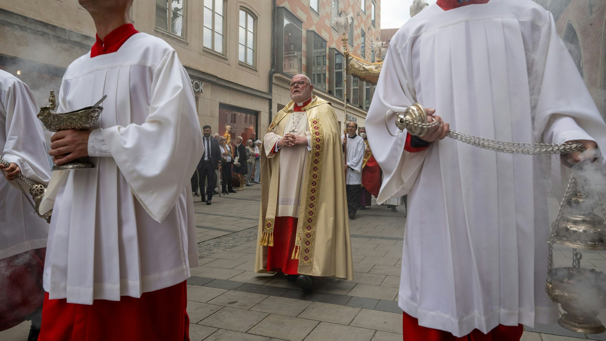 ARCHIV - 16.06.2022, Bayern, München: Gläubige nehmen in der Innenstadt an einer Fronleichnam-Prozession mit Kardinal Reinhard Marx (M) teil. (