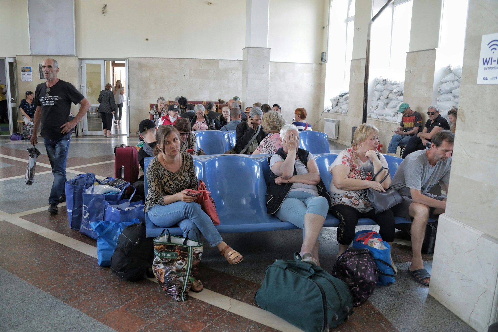 6. Juni 2023, Ukraine, Cherson: Menschen warten auf einen Evakuierungszug an einem Bahnhof.