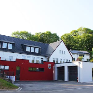 Das Bild zeigt vorne den Neubau des Feuerwehrgerätehauses in Kronenburg, dahinter und etwas erhöht im Hang das Dorfgemeinschaftshaus.