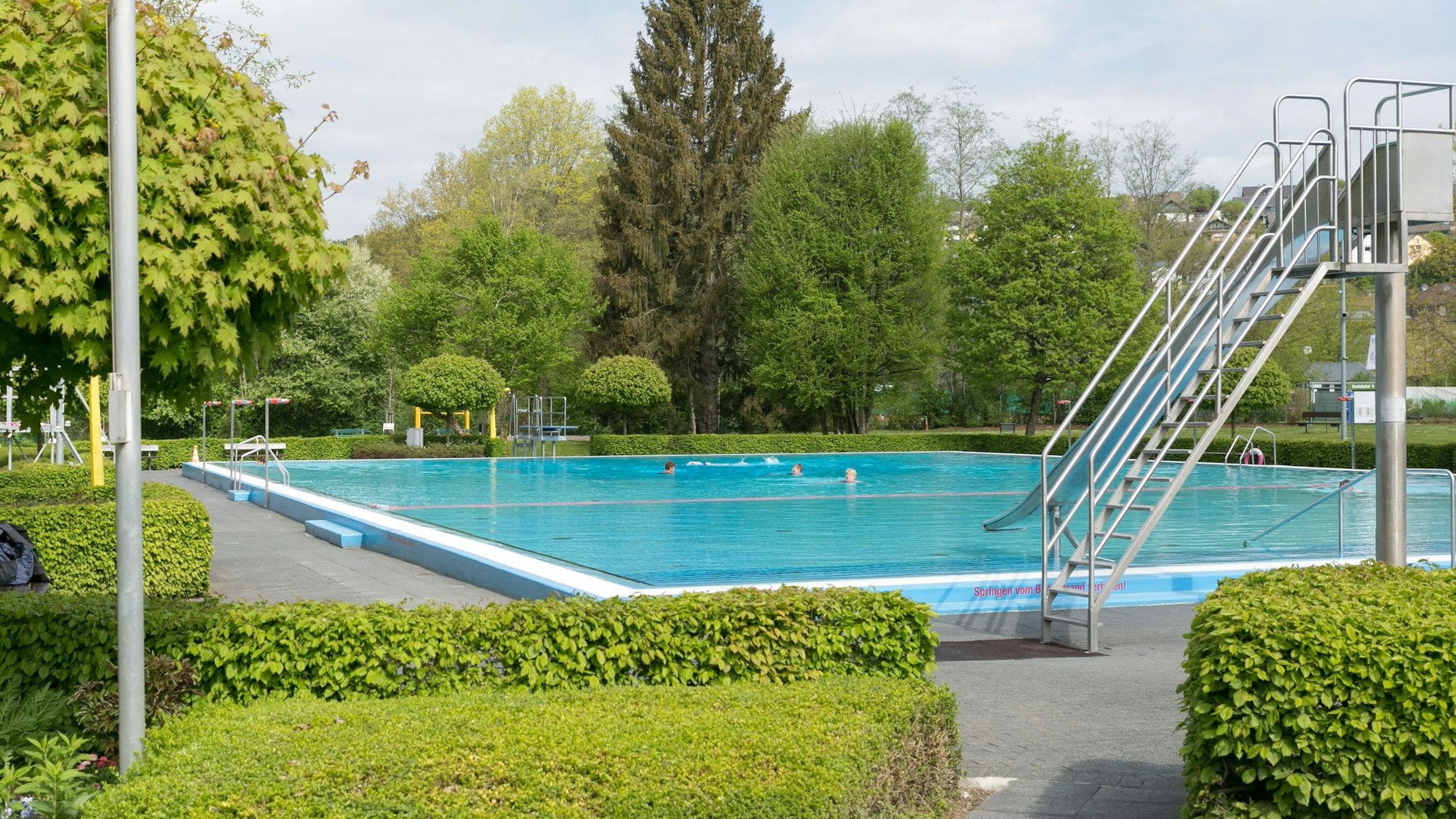 Blick auf das Schwimmbecken samt Rutsche des Freibads Bielstein.
