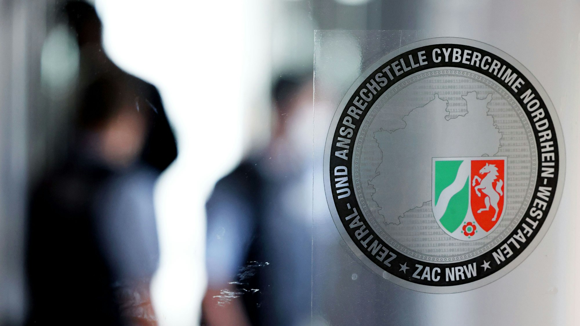 Das Logo der zentralen Anlaufstelle für Cybercrime (ZAC) hängt an einer Glastür.