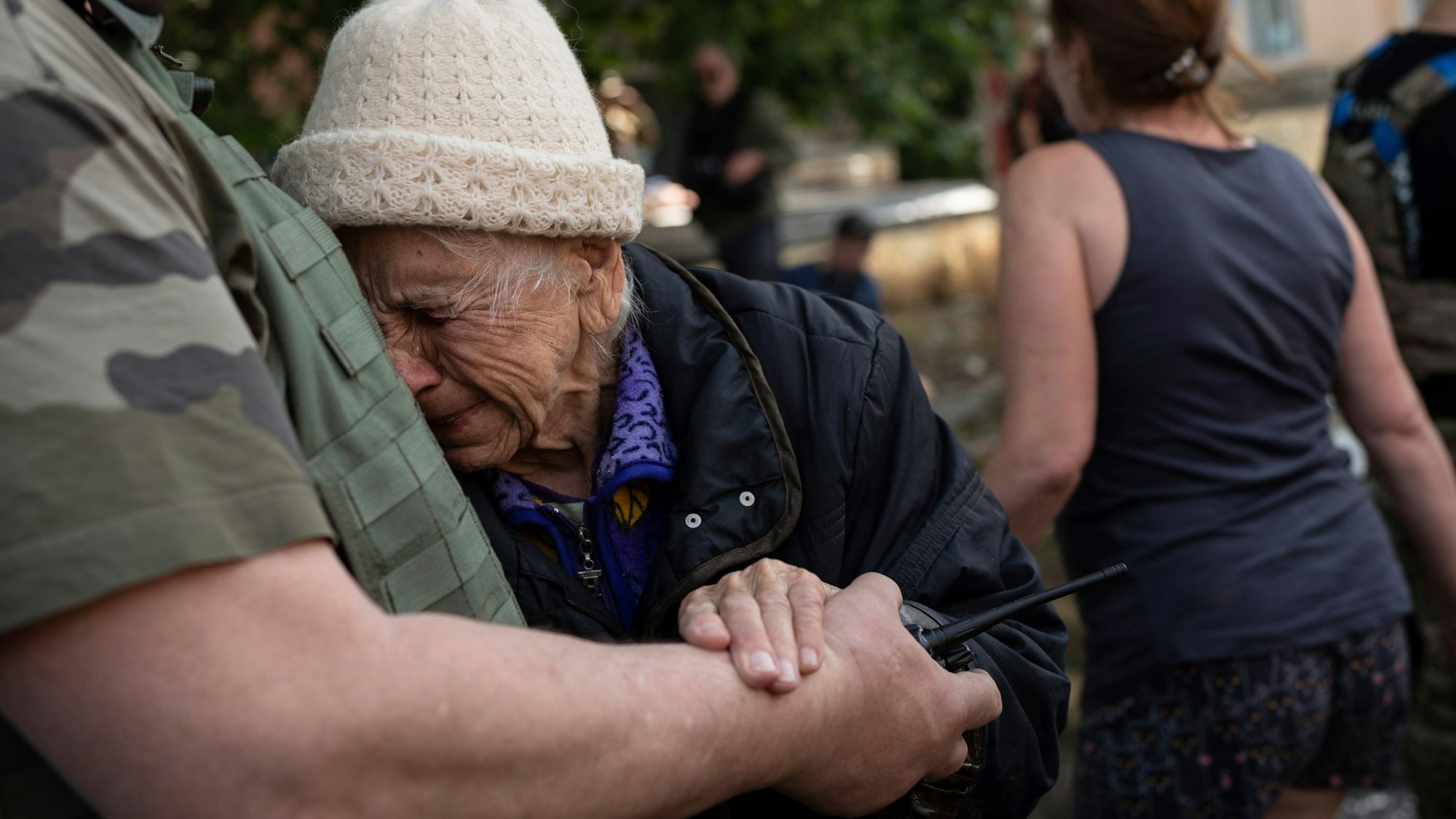 07.06.2023, Ukraine, Cherson: Eine Frau weint, als sie aus einem überfluteten Viertel evakuiert wird. Nach der Zerstörung des Kachowka-Staudamms in der Südukraine sind laut Angaben der russischen Besatzer im von ihnen kontrollierten Teil des Gebiets Cherson bis zu 40 000 Menschen von den schweren Überschwemmungen betroffen. Foto: Roman Hrytsyna/AP/dpa +++ dpa-Bildfunk +++