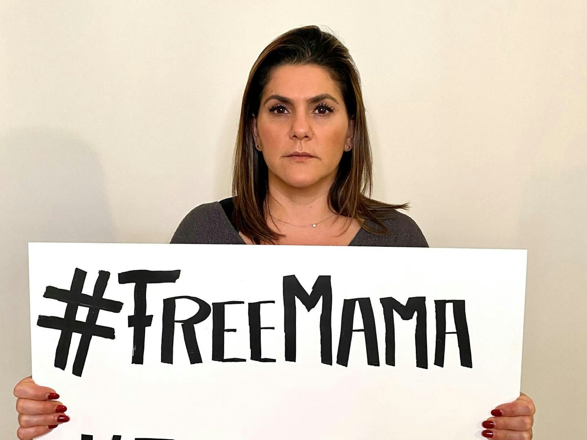 Mariam Claren mit einem Plakat mit der Aufschrift „Free Mama“