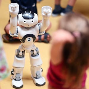 Ein Roboter macht den Kindern Bewegungsübungen vor.