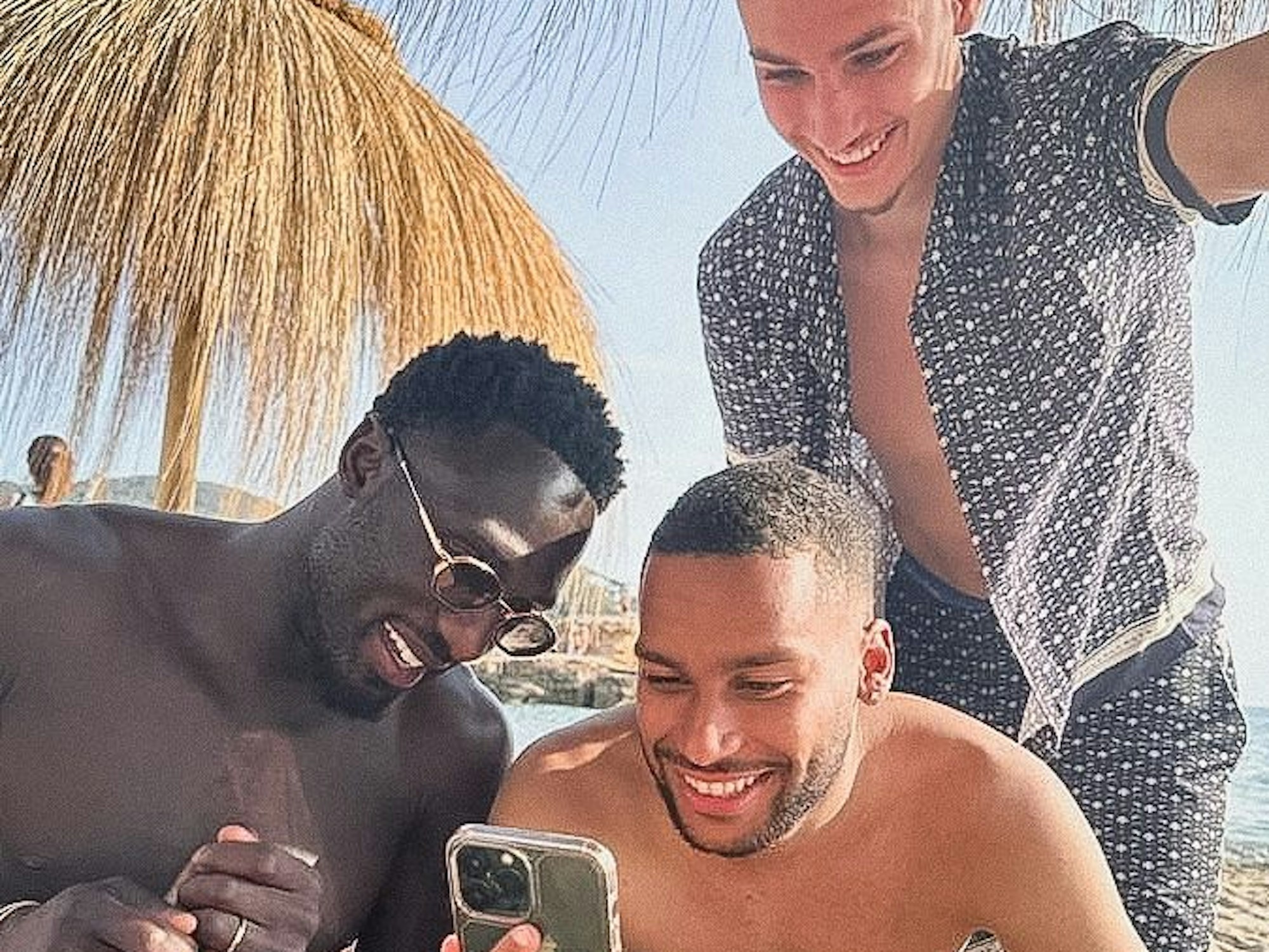 Kingsley Schindler, Linton Maina und Tim Lemperle sitzen in Ibiza am Strand