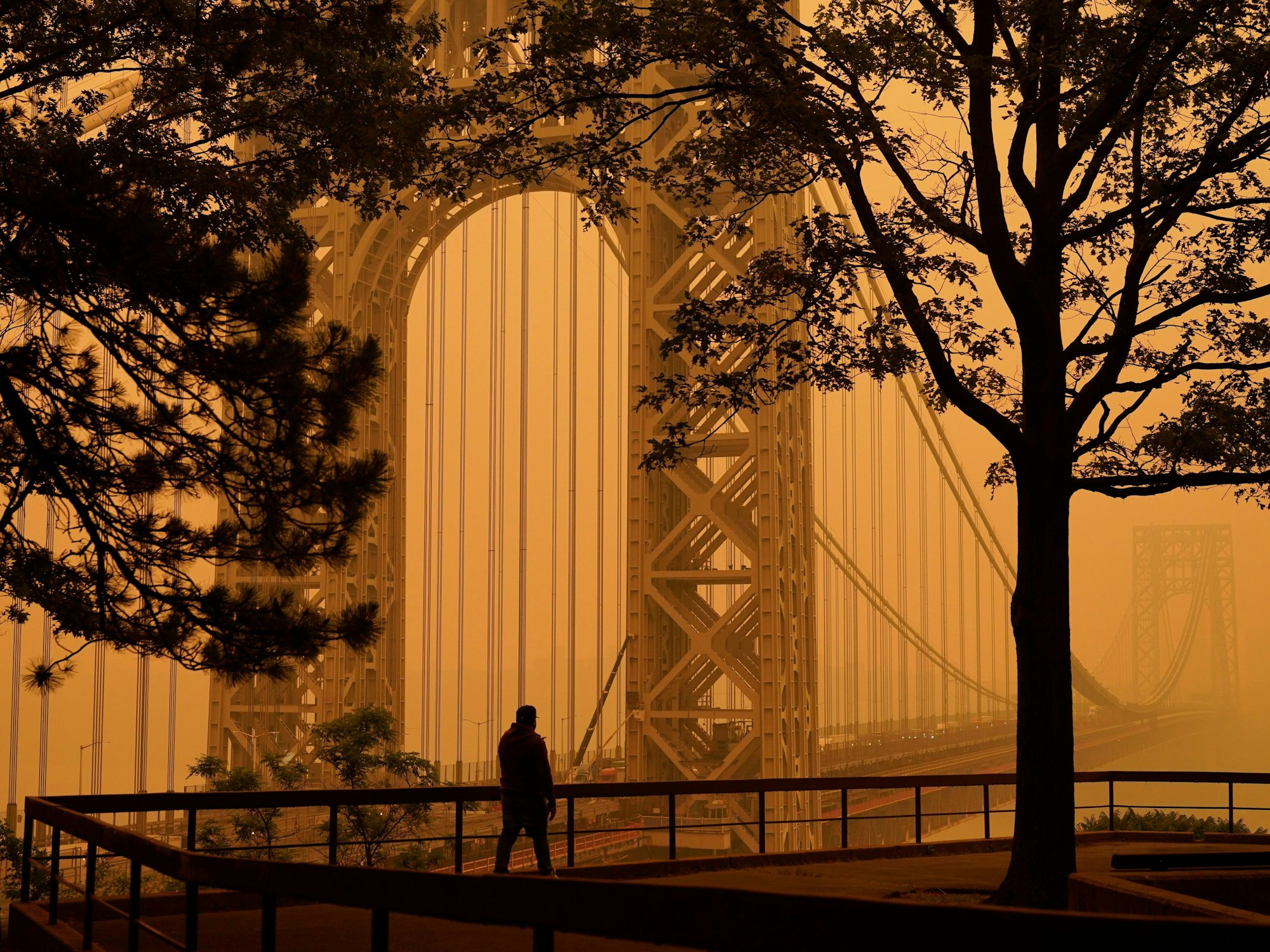 Ein Mann geht durch den Dunst vor der George Washington Bridge.