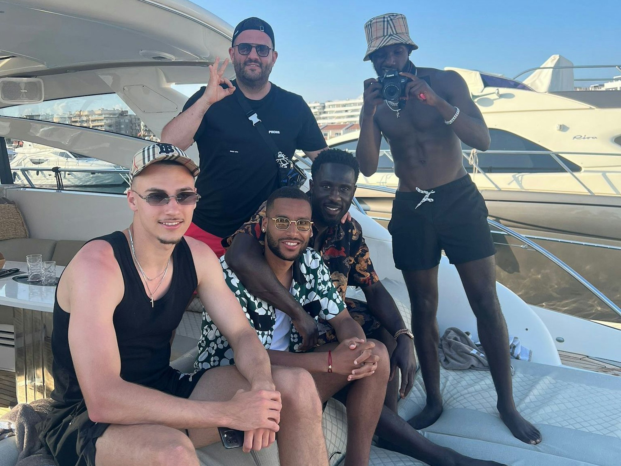 Tim Lemperle, Linton Maina und Kingsley Schindler sitzen in Ibiza auf einem Boot.