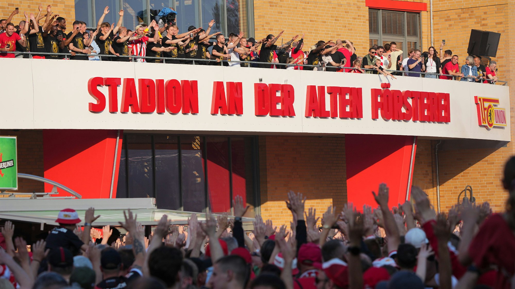 Unions Spieler und Fans feiern vor dem Stadion-Eingang.