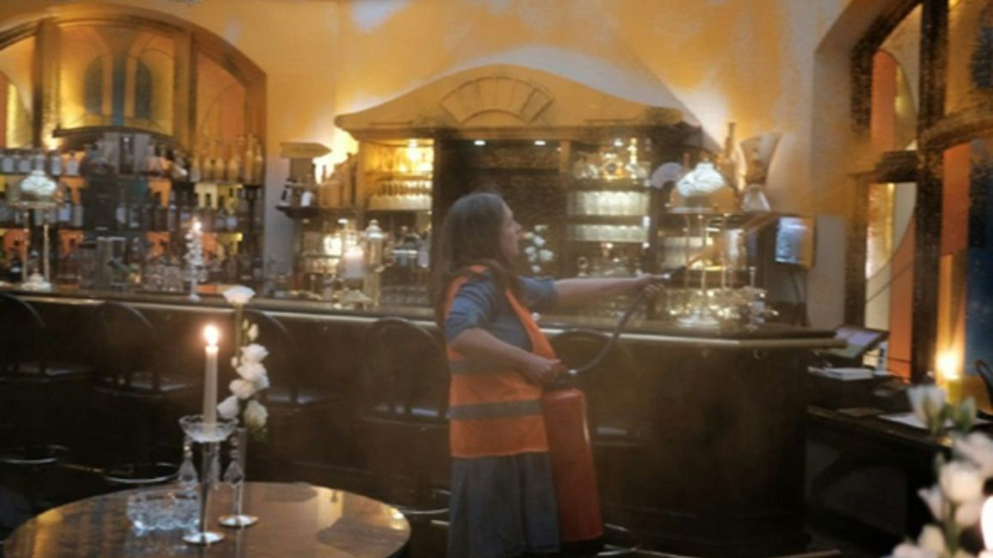 Protestaktion auf Sylt: Eine Aktivistin der Letzten Generation versprüht in einer Luxus-Bar auf der Urluabsinsel organe Farbe. Das Foto wurde von der Letzten Generation bereitgestellt.