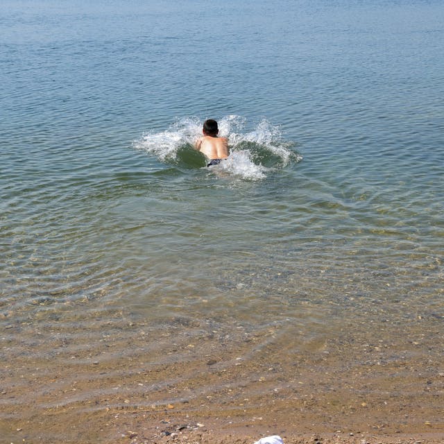 Ein Schwimmer springt in den Pescher See.