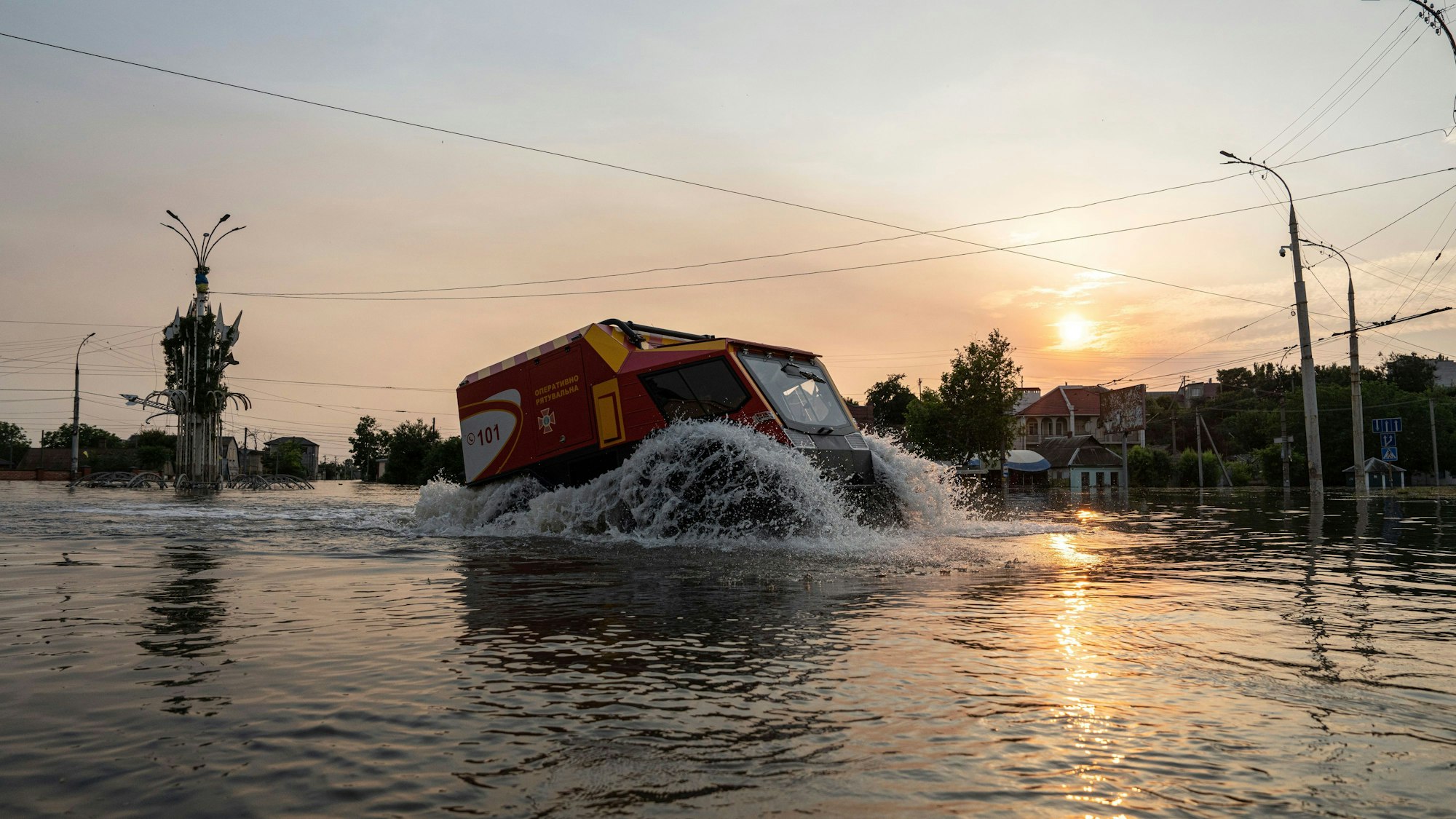 Rettungskräfte evakuieren Menschen in einem überschwemmten Stadtteil von Cherson mit einem Sumpf-Fahrzeug.