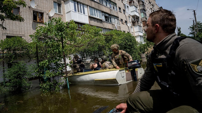8. Juni 2023, Ukraine, Cherson: Ukrainische Soldaten kommen mit Booten, um Menschen in einem überfluteten Stadtteil zu evakuieren. Die Fluten eines zusammengebrochenen Staudamms stiegen in der Südukraine weiter an und zwangen Hunderte von Menschen zur Flucht aus ihren Häusern.