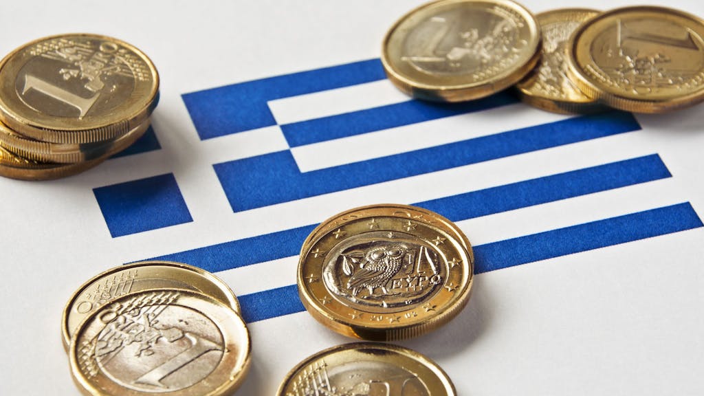Trinkgeld liegt auf einer Griechenlandflagge.