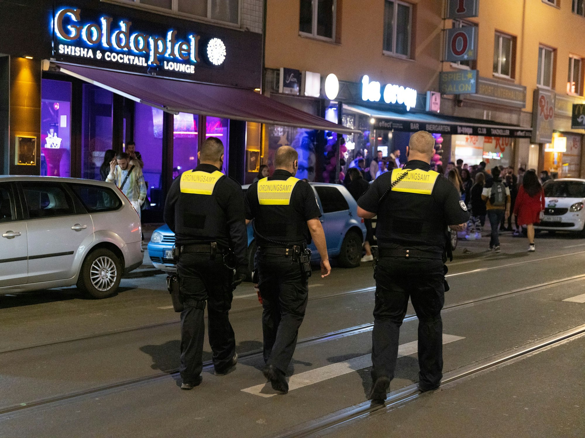 Drei Ordnungsamt-Mitarbeiter laufen über die Zülpicher Straße.