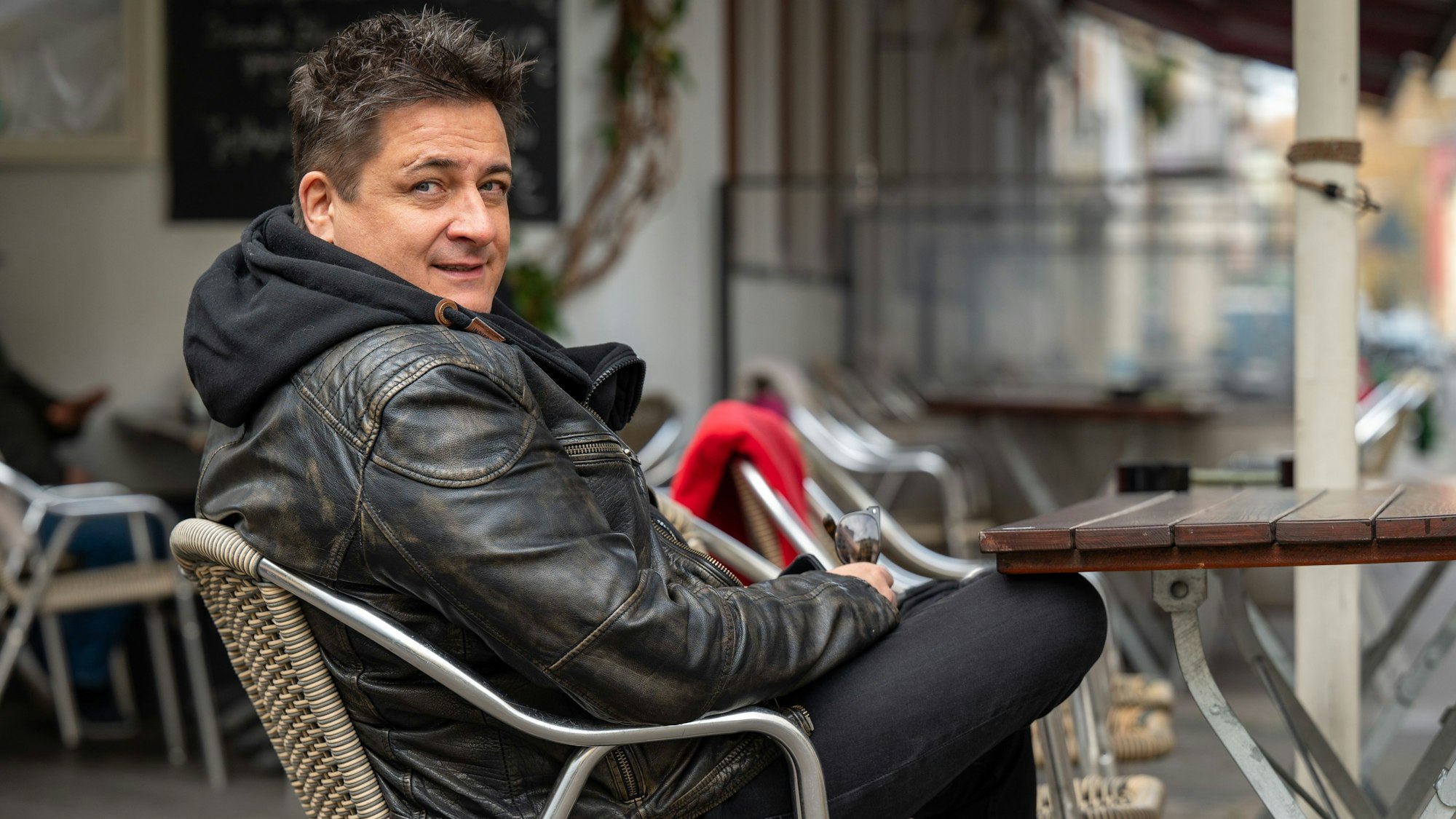 Micky Nauber von den Domstürmern sitzt draußen auf einem Stuhl im Filos in der Südstadt.