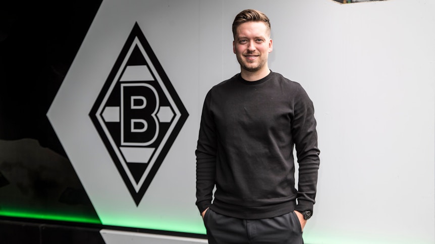 Jonas Spengler, Trainer des Frauen-Teams von Borussia Mönchengladbach. Er steht vor ener Borussia-Raute.