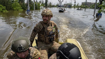 Ukrainische Soldaten fahren mit Schlauchbooten durch überflutete Straßen nach dem Dammbruch in der Region Cherson.
