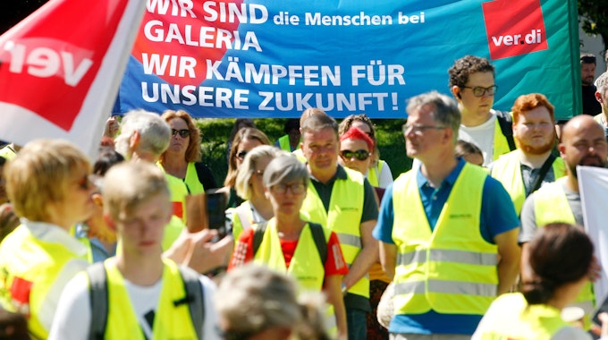 09.06.2023, Nordrhein-Westfalen, Essen: Mitarbeiter von Galeria Karstadt Kaufhof demonstrieren mit einem Plakat «Wir sind die Menschen bei Galeria - Wir kämpfen für unsere Zuknft».&nbsp;