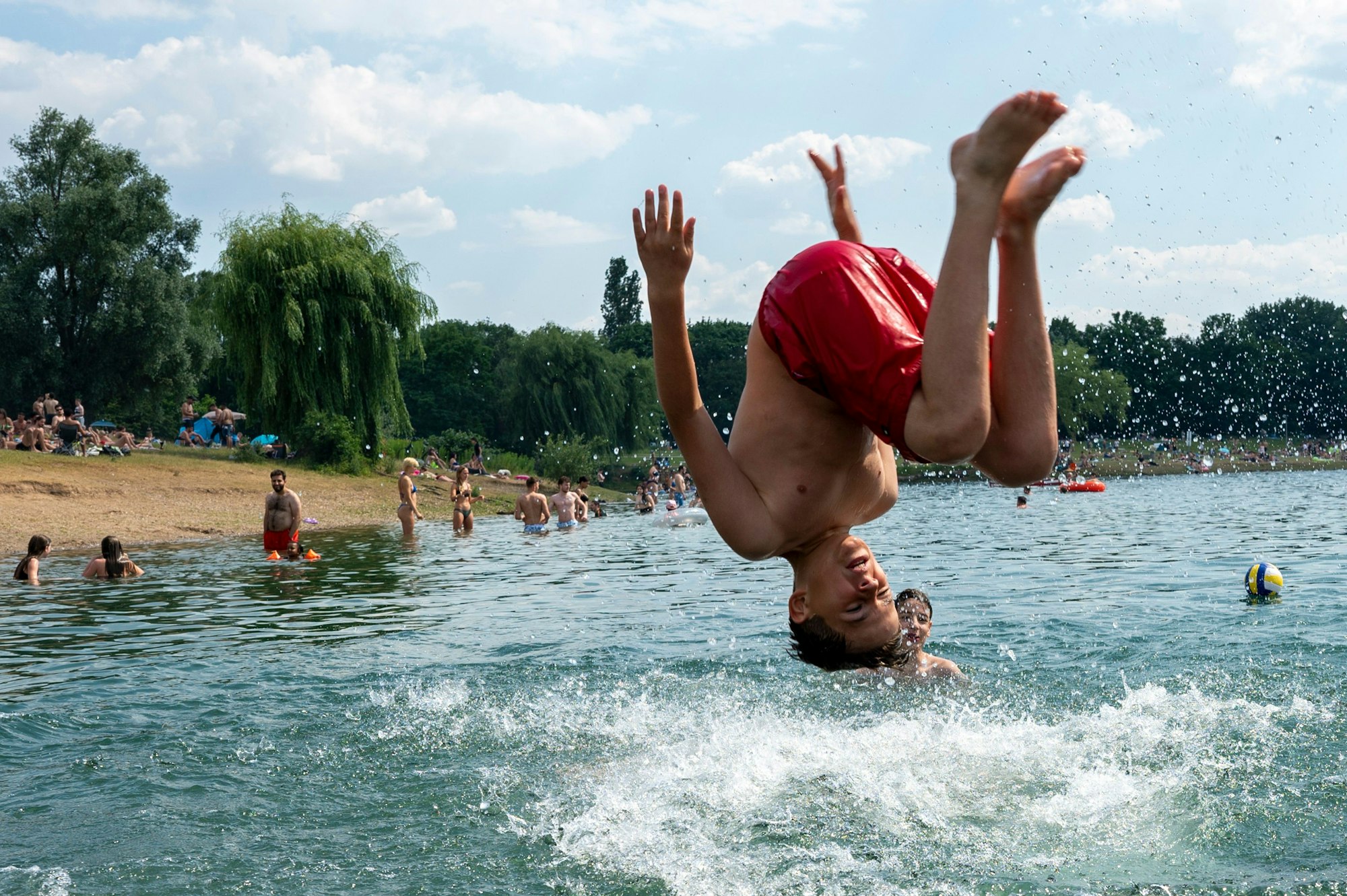 Ein Junge springt über Kopf in den Fühlinger See.