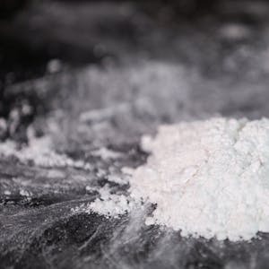 Das Bild zeigt ein weißes Häufchen Kokain auf einen Spiegel.