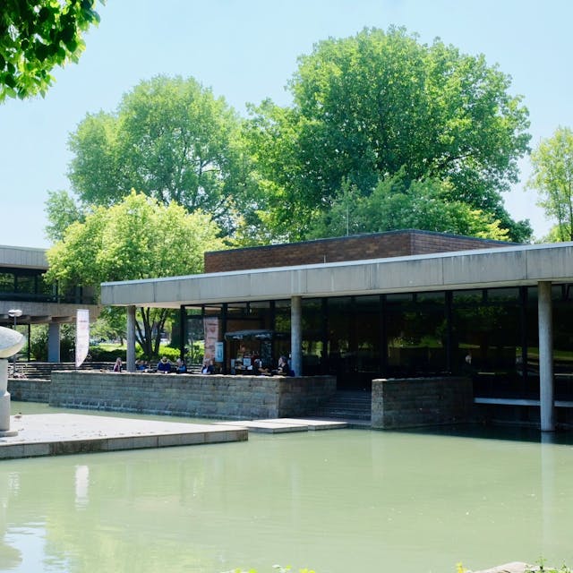 Ein Teich mit dem Museum im Hintergrund.