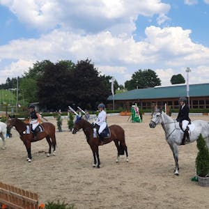 Temperaturen wie im Hochsommer auf dem Silberberghof bei Wipperfürth-Kreuzberg. Reiter und Reiterinnen sitzen auf Pferden in einer Reihe.