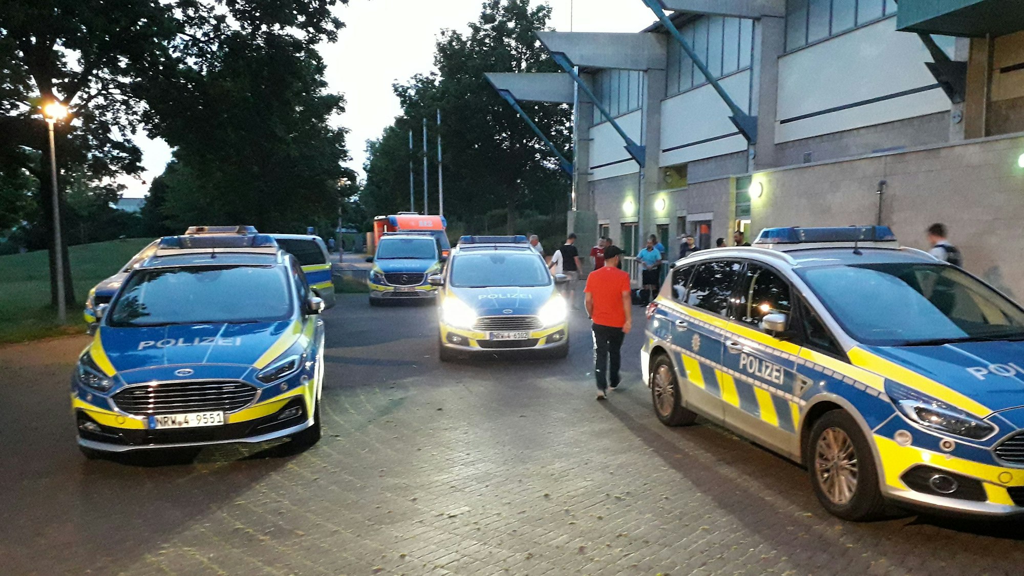 Zahlreiche Polizeifahrzeuge stehen vor dem Erftstadion in Euskirchen. Die Beamten waren nach Ausschreitungen bei einem Fußballspiel alarmiert worden.