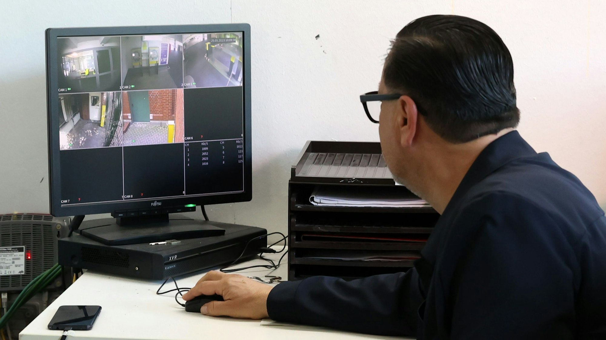 Parkhauswächter Tamer Bakirci schaut auf einen Bildschirm der Video-Überwachung.

