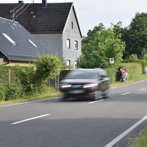 Ein Auto fährt eine Landstraße entlang.