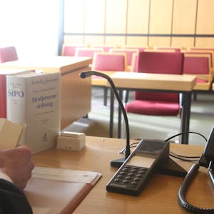 Der Gerichtssaal im Amtsgericht Siegburg. Auf einem Tisch liegen Akten und Gesetzbücher.