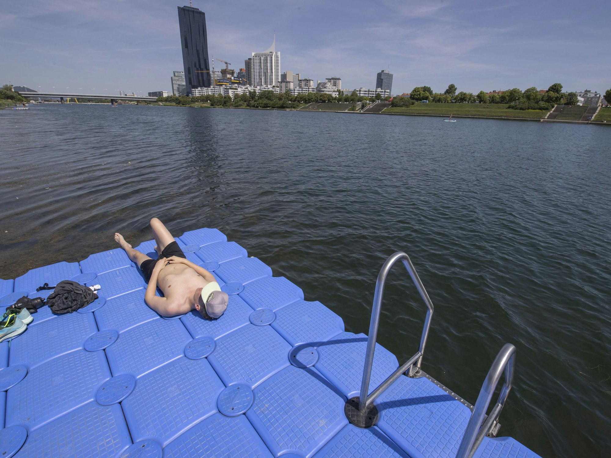 Ein Badegast genießt die Sonne auf der Donauinsel