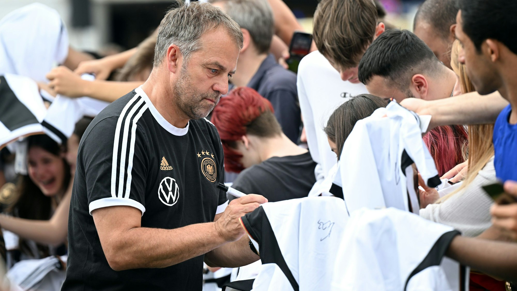 Bundestrainer Hansi Flick schreibt Autogramme.