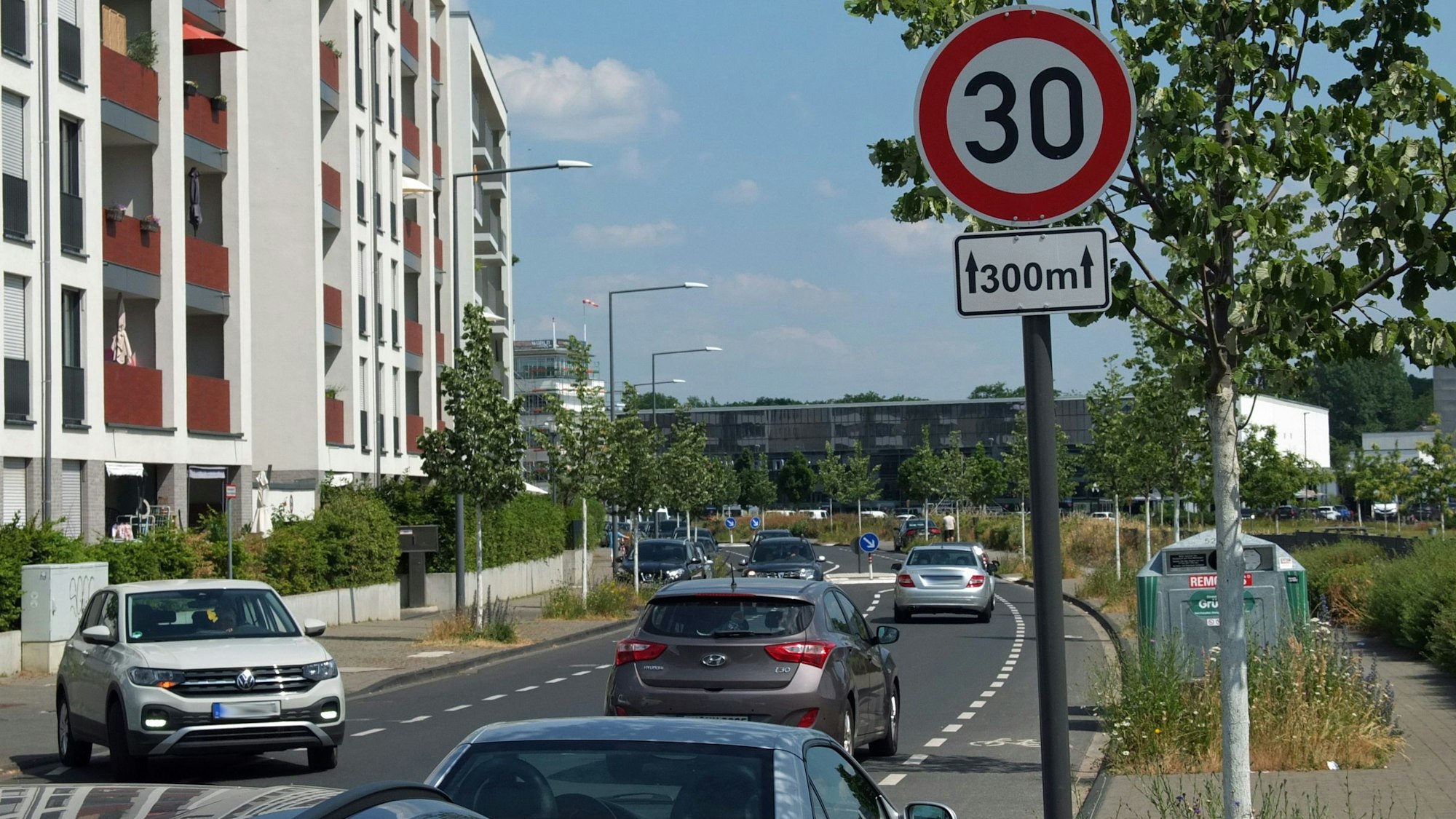 Straßenabschnitt mit einem Tempo 30 Schild, auf dem in beide Richtungen Autos unterwegs sind