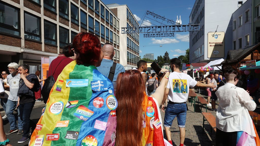 Menschen tragen Regenbogenflaggen und laufen bei der CSD-Demonstration in Köln mit.&nbsp;